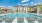 The pool area at our apartments in Fort Worth, featuring beach chairs, a shade structure, and view of the apartments.